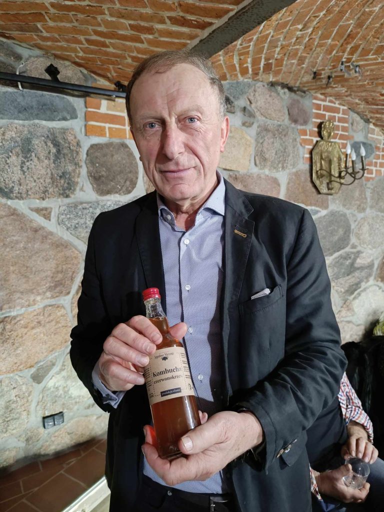 Gospodarz szkolenia pan Stanisław Małachowski CN Zielenin w ręku z produktem do picia- kambucha