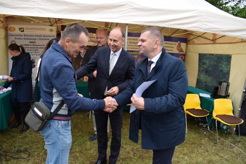 Wicemarszałek Adam Gawrylik i Dyrektor Aleksander Mach gratulują laureatowi wystawy gołębi.