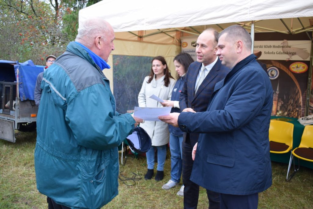 Wicemarszałek Adam Gawrylik i Dyrektor Aleksander Mach wręczają nagrody laureatowi wystawy gołębi.