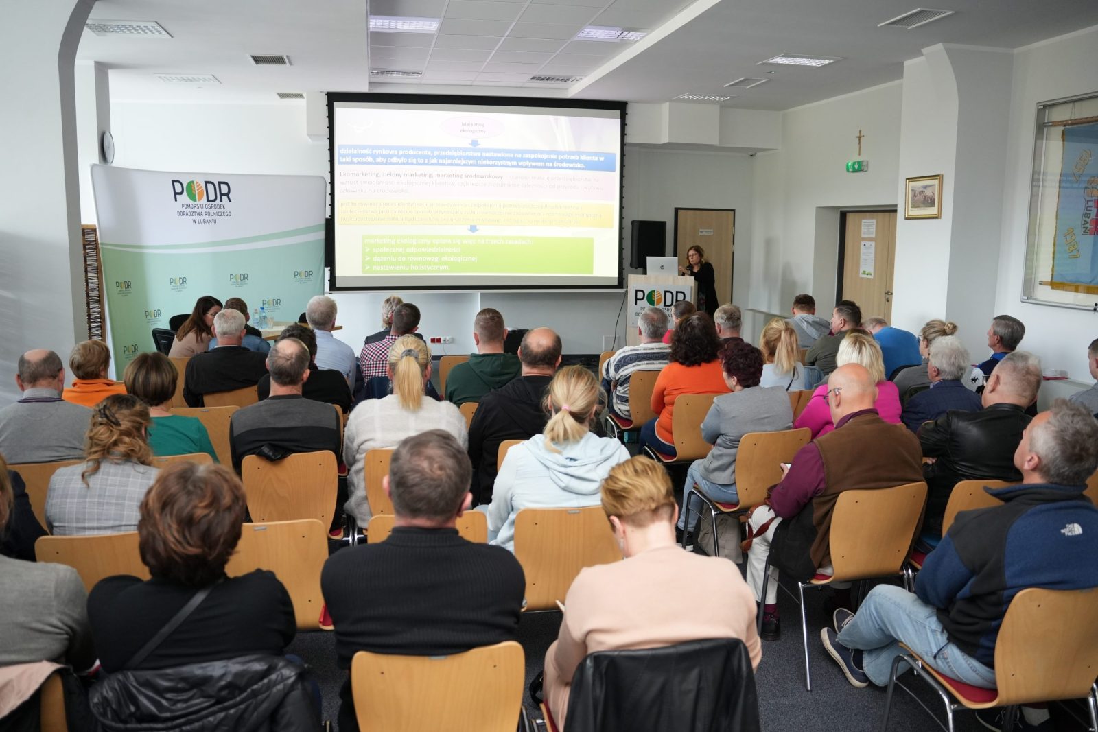 uczestnicy seminarium, w tle wykład na temat marketingu ekologicznego prezentuje dr Joanna Smoluk-Sikorska