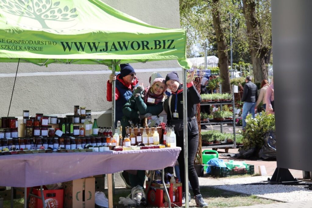 Stoisko wystawcy z banerem „jawor.biz”; sprzedawcy prezentują lokalne produkty pod namiotem targowym.