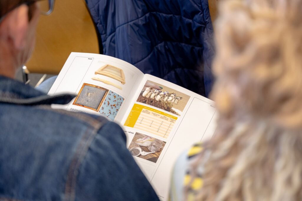 Uczestnik przeglądający materiały szkoleniowe dotyczące pszczelarstwa