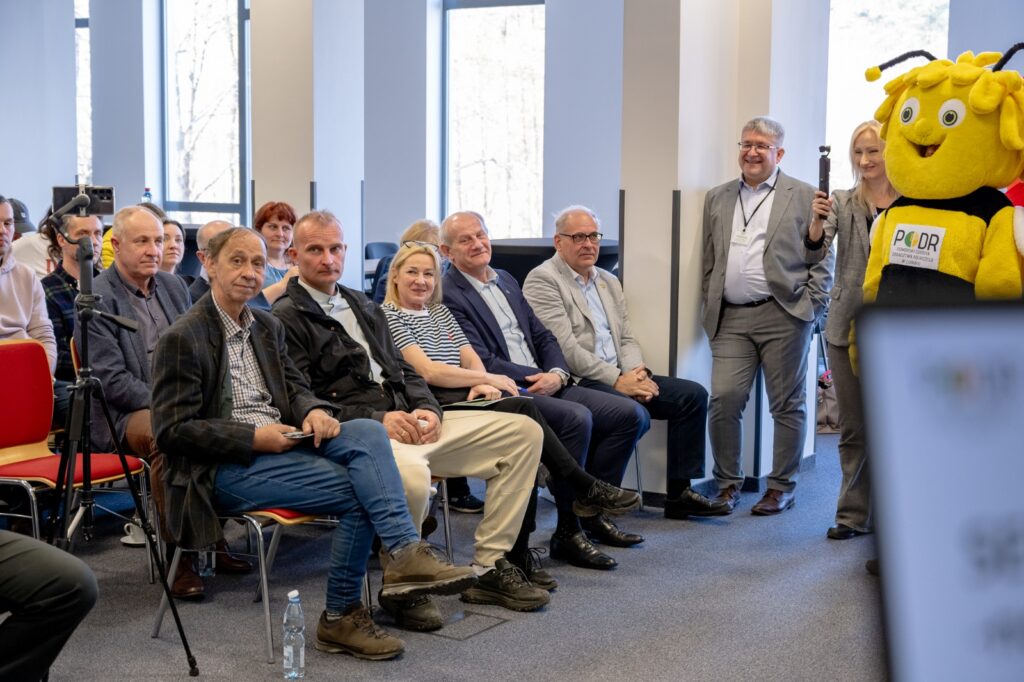 Uczestnicy siedzący w pierwszym rzędzie podczas konferencji