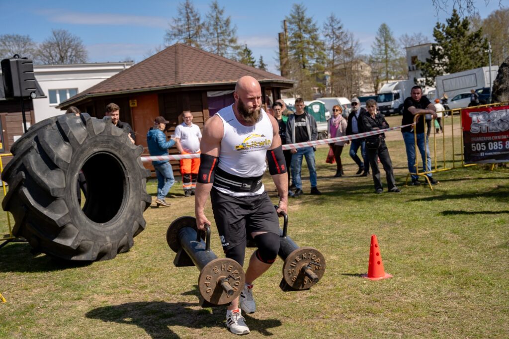 Zawodnik biegnący z ciężarem podczas konkurencji siłowej