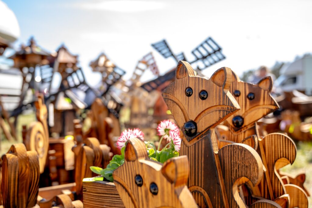 Drewniane dekoracje ogrodowe i rękodzieło prezentowane na stoisku