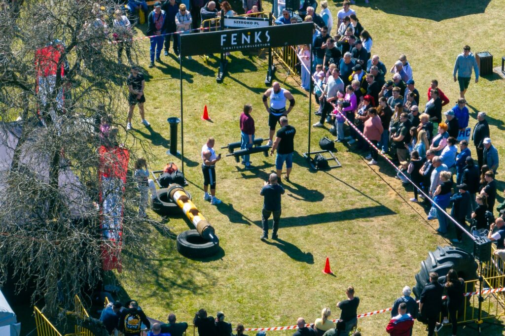 Pokaz Strongman Show widziany z góry – zawodnicy oraz publiczność zgromadzona wokół placu